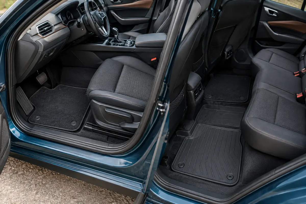 Tapis de voiture en moquette et en caoutchouc présentés dans un habitacle pour comparer leurs formats