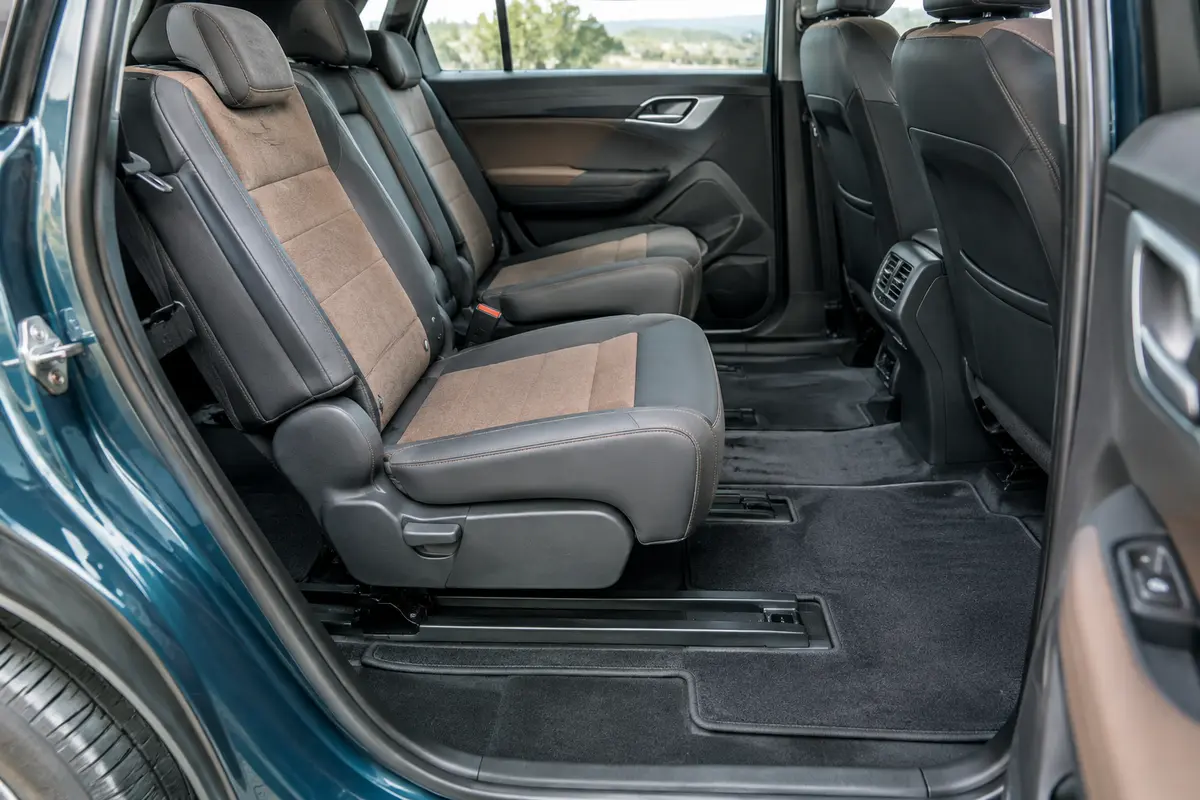 Plancher d’une voiture familiale avec tapis ajustés et rails dégagés sous une banquette coulissante