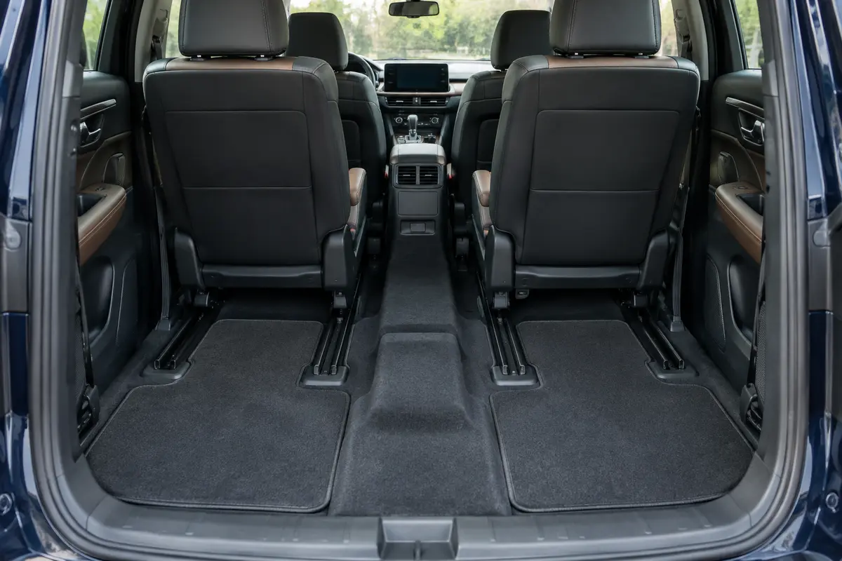 Tapis ajustés aux pieds de la deuxième rangée d’un SUV familial, avec tunnel central dégagé