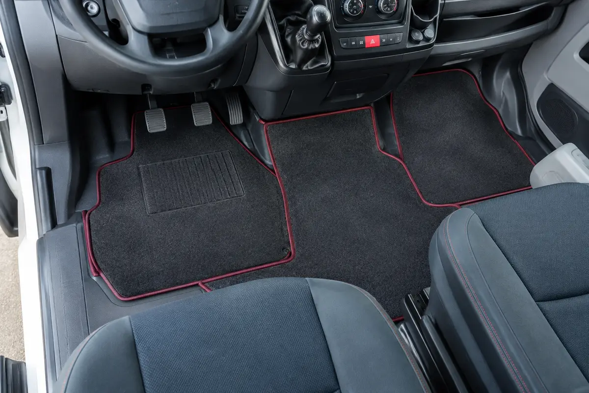 Jeu de tapis de sol anthracite à bordure bordeaux installé dans l’habitacle d’un Citroën Jumper II.