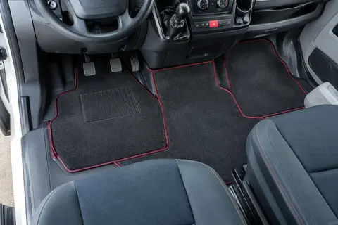 Jeu de tapis de sol anthracite à bordure bordeaux installé dans l’habitacle d’un Citroën Jumper II.
