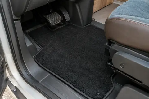 Tapis noir en polypropylène posé au sol côté conducteur dans un habitacle de camping-car propre.