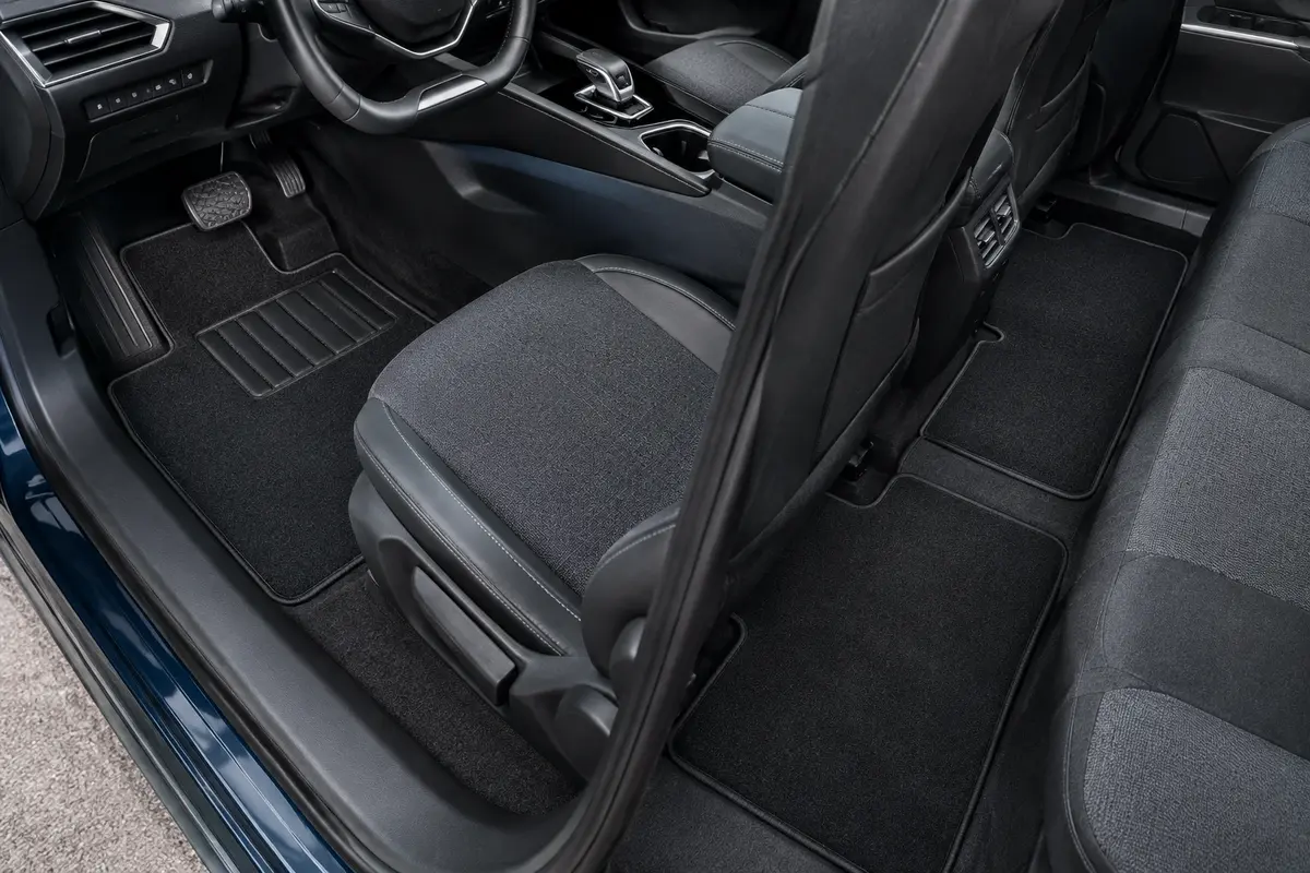 Jeu de quatre tapis noirs en moquette avec talonnette, installé dans l’habitacle d’une Peugeot 208