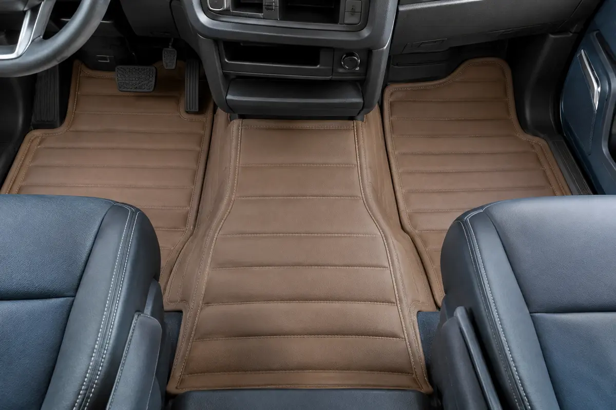 Jeu de tapis de cabine marron clair en simili cuir avec coutures beiges, posé dans un camion