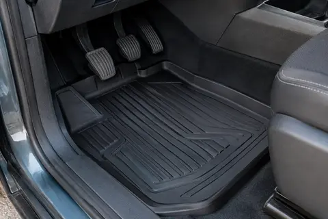 Tapis de sol monobloc noir en caoutchouc 3D à bords relevés dans un habitacle d’utilitaire.