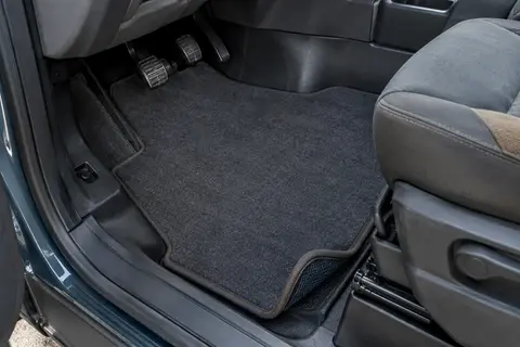 Tapis en feutre aiguilleté ajusté au plancher d’un camping-car Ford Transit, avec bords gansés