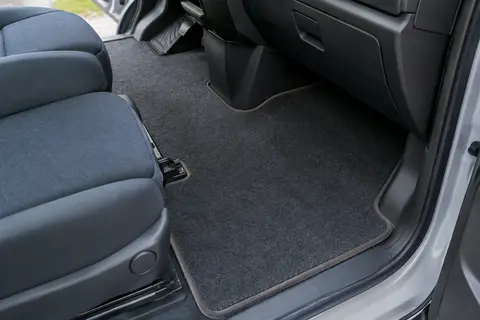 Tapis de sol Kovvar en feutre aiguilleté avec bordure effet nubuck dans un habitacle de fourgon propre.