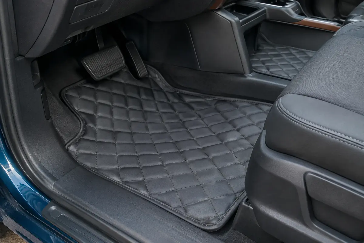 Deux tapis de sol matelassés graphite en cuir synthétique installés dans l’habitacle d’un utilitaire