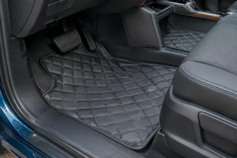 Deux tapis de sol matelassés graphite en cuir synthétique installés dans l’habitacle d’un utilitaire