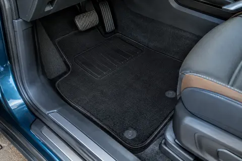 Tapis noirs en moquette aiguilletée avec talonnette renforcée dans un habitacle de SUV