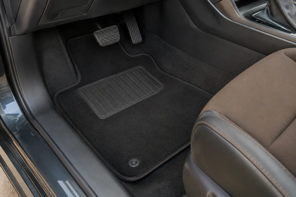 Jeu de tapis noirs en velours installé dans l’habitacle, avec bordure antidérapante et renfort conducteur