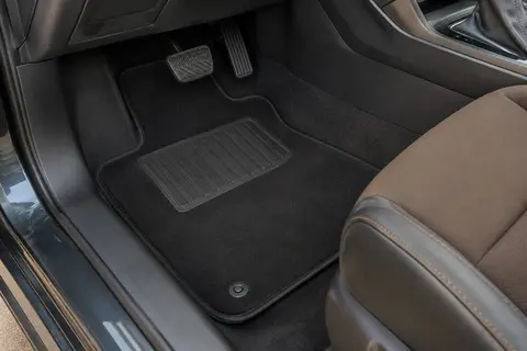 Jeu de tapis noirs en velours installé dans l’habitacle, avec bordure antidérapante et renfort conducteur