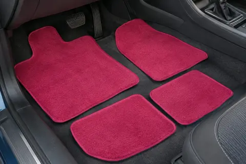 Jeu de quatre tapis de voiture rose à poils posé dans un habitacle propre