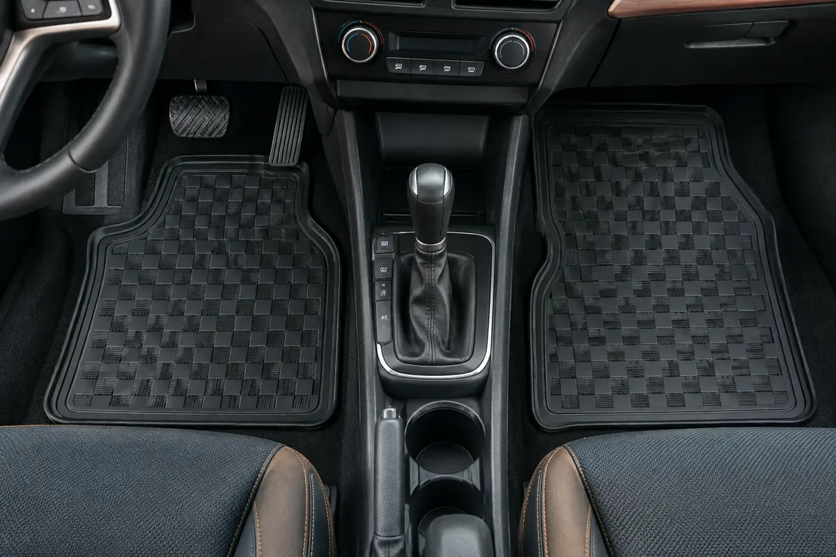 Paire de tapis avant en caoutchouc noir à motif damier installée dans un habitacle automobile propre