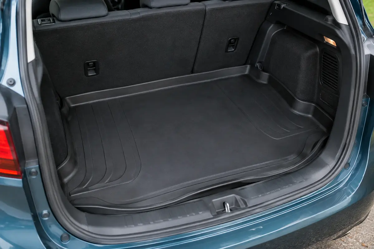 Tapis de coffre noir à rebords hauts, installé dans l’espace de chargement d’une voiture.
